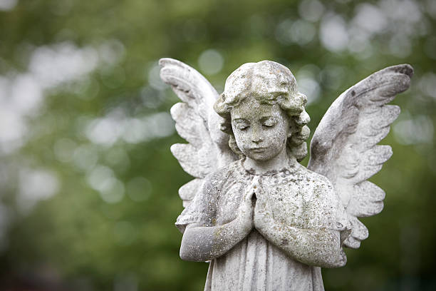 Stone cherub praying in graveyard. Taken with Canon 1Ds MarkIII